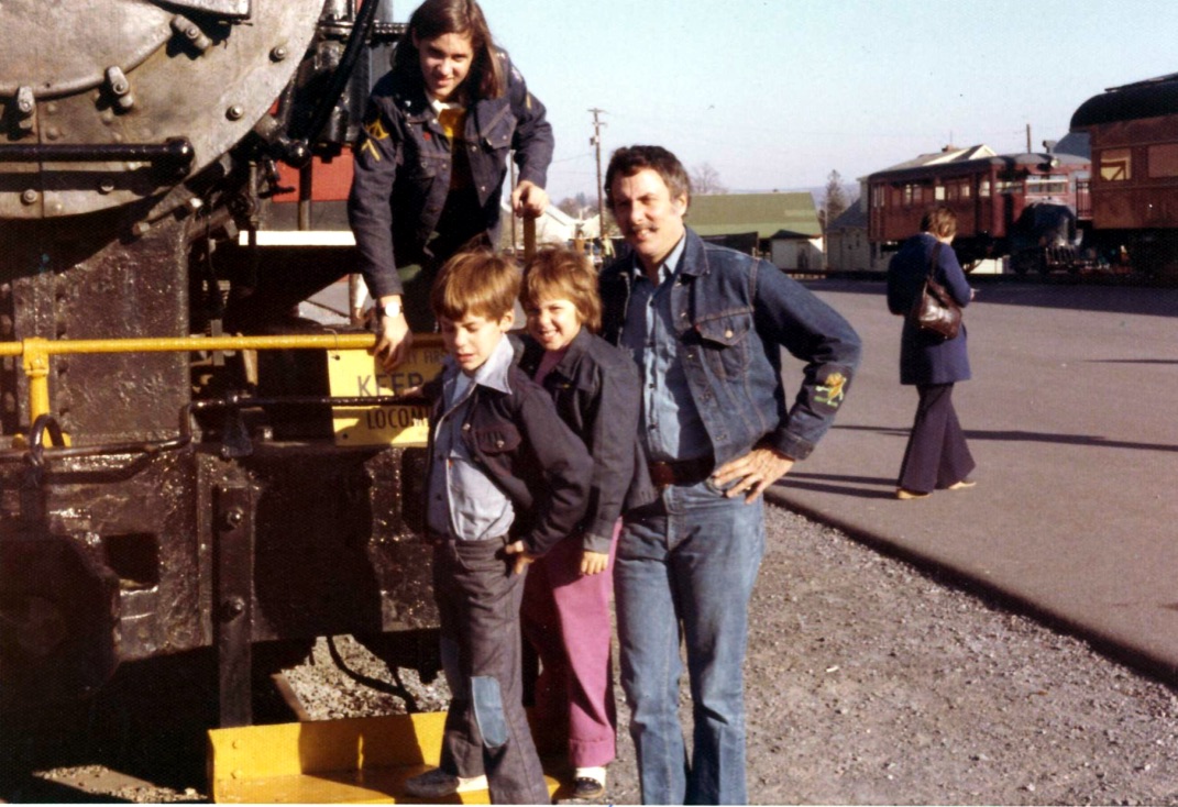 Marshall with his children beside a locomotive