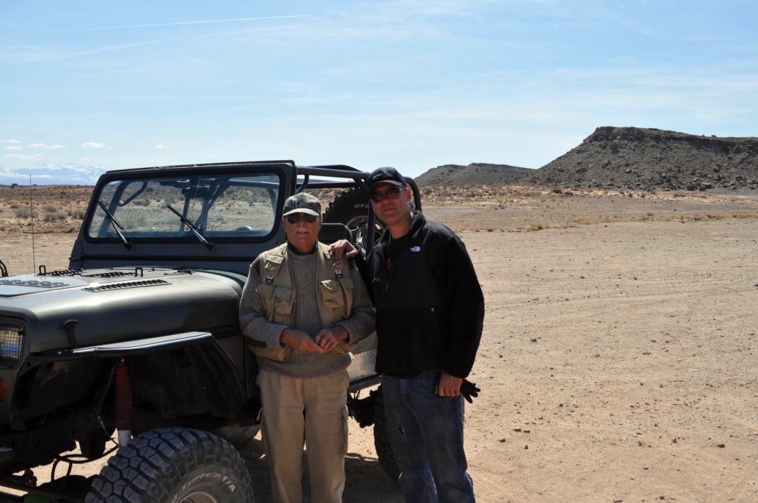 Marshall on a desert adventure beside an off-road vehicle