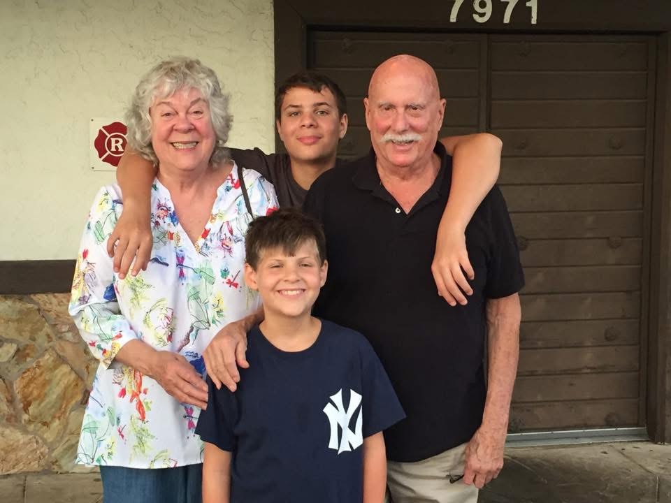 Marshall and Marian smiling with two of their grandsons